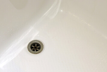 sewer drain in a white bath