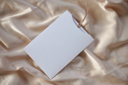 The gift certificate lies on a beige silk fabric. holiday gift