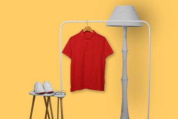 Red polo shirt hanging on display rack isolated on plain background