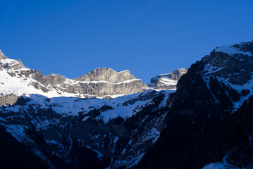 Aerial view of mountain panorama at the Swiss Alps seen from ski resort Engelberg, focus on background. Photo taken February 9th, 2022, Engelberg, Switzerland.