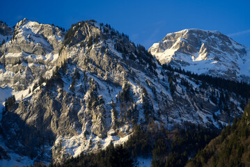 Aerial view of mountain panorama at the Swiss Alps seen from ski resort Engelberg, focus on background. Photo taken February 9th, 2022, Engelberg, Switzerland.