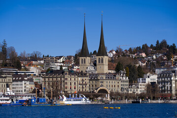 Roman catholic Court Church at City of Luzern on a sunny winter day with lake Luzern in the foreground, focus on background. Photo taken February 9th, 2022, Lucerne, Switzerland.