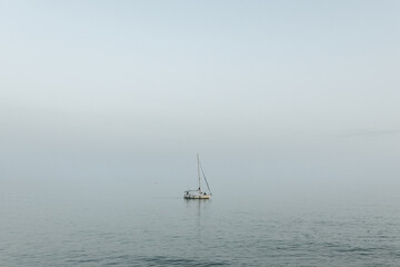 Lonely sailboat out on the ocean off the Mediterranean Sea in Sitges, Spain.