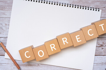 「CORRECT」と書かれた積み木、ペン、ノート