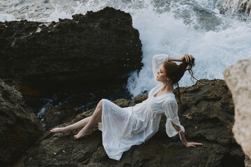 Barefoot woman in a white dress lying on a stone in a white dress nature landscape