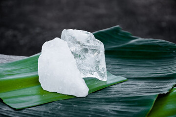 Transparent crystal alum stone or Potassium alum on banana leaf. Chemical compound. Concept for...