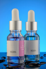 Bottle of liquid on a blue background with reflection. can be used as cosmetic oil