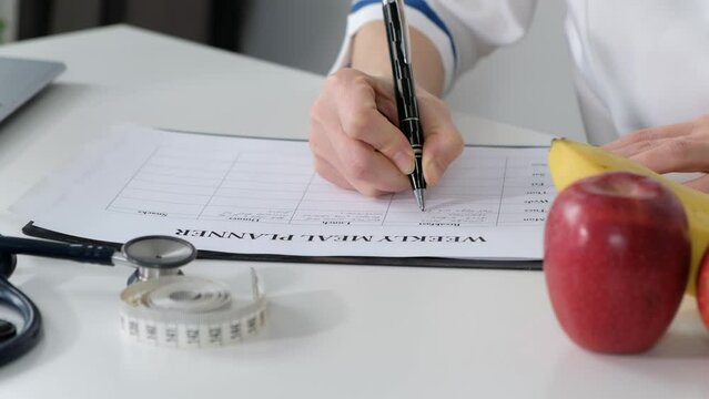 Nutritionist giving consultation to patient with healthy fruit and vegetable, wright nutrition weekly plan, diet concept
