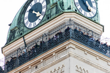 People gathered at top of building with clock