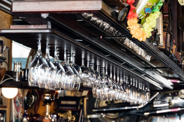 Clean wine glasses hanging ready in a bar