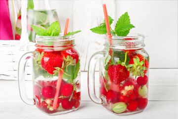 Fresh cool drink of ripe juicy cherry, strawberry, currant and gooseberry berries