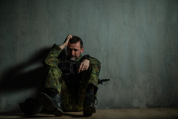 Fototapeta na wymiar Frustrated military soldier sitting crying alone in boot camp.