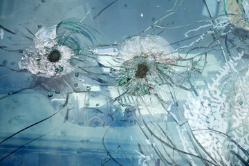 cracked and chipped broken glass background with bullet holes, war between Ukraine and Russia, february 2022