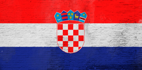 Full frame photo of a weathered flag of Croatia painted on a plastered brick wall.