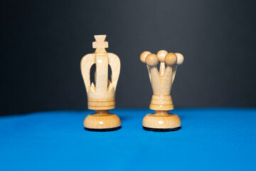 roi et reine d'échec en bois blanc sur fond bleu et noir