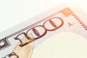 US 100 dollar bill close up. Number 100 on 100 dollar bill with sunlight. 100. Fragment of bills close-up. New sample money.