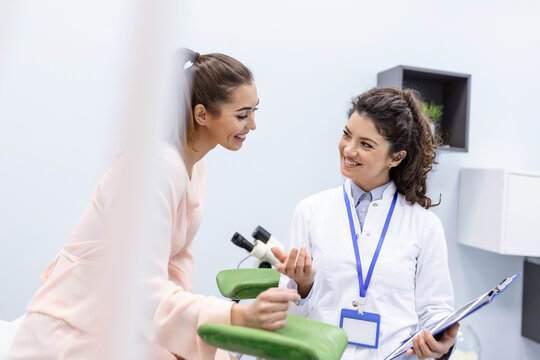 Gynecologist showing a picture with ultrasound to a young woman patient, explaining the features of women's health during a medical consultation in the office