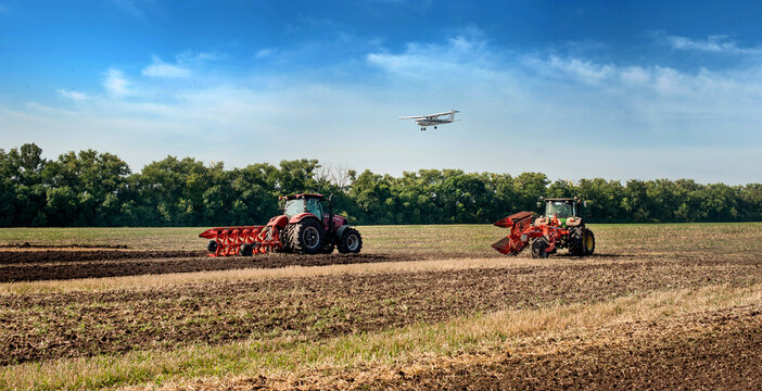 Bilogirya, Khmelnytsky region, UKRAINE - August 19, 2021: tractors with seeder at the demonstration of agricultural machinery, exhibition "Battle of agrotitans" seeder competition, and airplan at sky