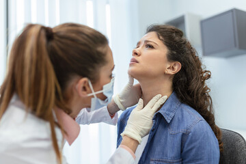 medicine, healthcare and medical exam concept - doctor or nurse checking patient's tonsils at...