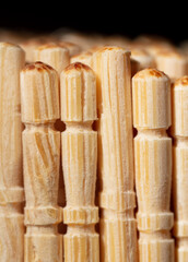Close up of wooden toothpicks on a black background.