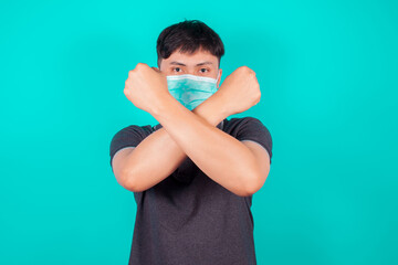 Asian man in medical face mask to protect Covid-19 on green background, Stop going outside, people to stay home, health and medicine concept