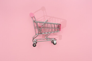 Empty decorative mini shopping basket on pink background