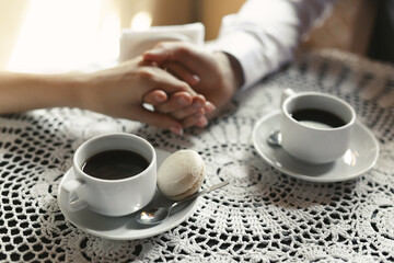 Beautiful wedding couple drinking coffee in a retro cafe