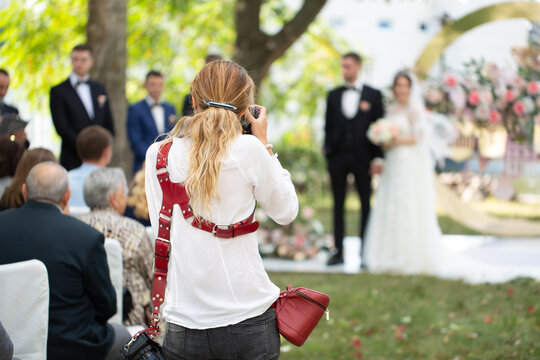Wedding photographer takes pictures of the bride and groom during the ceremony