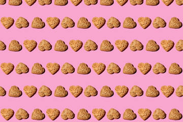 Heart shaped Oatmeal cookies, top view on trendy pink  background. Creative Pattern made of cookies. Repeating Oatmeal cookies pattern. Flat lay style.