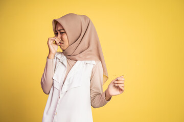 muslim woman covering nose with finger when bad smell