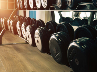 Fototapeta na wymiar Rows of dumbbells in the gym. Rack with heavy dumbbells in a fitness club. Workout bodybuilding concept.