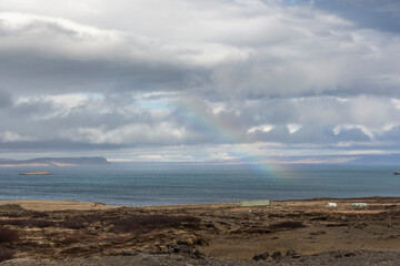 Scenery with dark clouds and rainbow over the raw coast of Snaefellsnes peninsula, Iceland