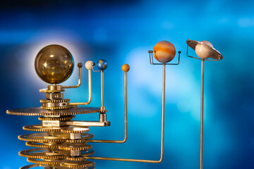 Model of the solar system made of brass close-up on a blue background