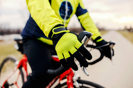 Close up of a hand with glove holding a bicycle handle.