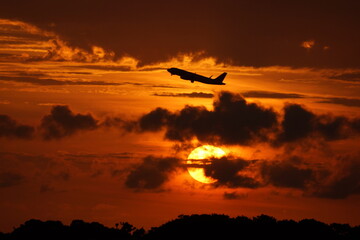 Fototapeta na wymiar When the rising plane passes on top of the rising sun