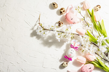 Happy Easter background with blooming cherry, tulips and cute rabbit. Spring festive flat lay