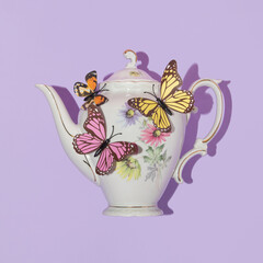 Spring creative layout with english garden teapot with colorful butterflies on pastel purple...