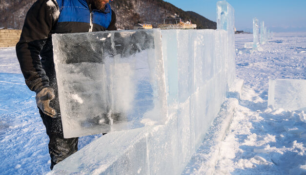Sculptor builds a wall from an ice block on Lake Baikal.