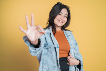 woman smiling with okay hand gesture on isolated background