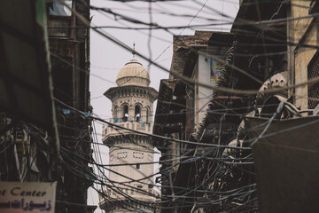 View to the White Mosque Minaret and Wires in the Peshawar City Center Street, Pakistan