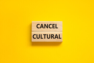 Cancel cultural symbol. Concept words Cancel cultural on wooden blocks on a beautiful yellow table yellow background. Business and cancel cultural concept, copy space.