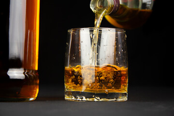 Pouring a glass of dark amber-colored whiskey - Powered by Adobe