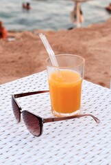 orange juice and sunglasses on the beach cocktail drinks beverage fresh fruits tropical citrus vitamin sea seaside ocean resort holiday vacations sand