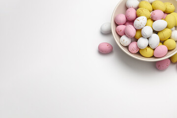 Colorful glazed chocolate candies in plate on white background