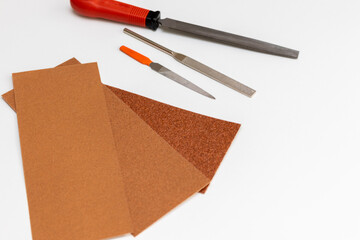 白い机に置かれた鉄工やすりと紙やすり