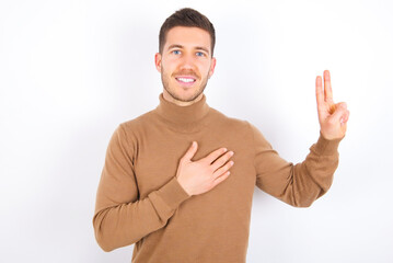 young caucasian man wearing grey turtleneck over white background smiling swearing with hand on...