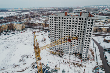 construction of a multi-storey building with cranes and builders top view