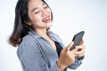 Young asian woman using mobile cell phone typing sms message