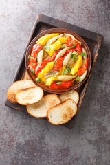 Escalivada or escalibada Spanish traditional dish of smoky grilled vegetables closeup in the wooden board on the table. Vertical top view from above