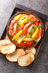 Escalivada Catalan Roasted Vegetables with toasts closeup in the wooden board on the table. Vertical top view from above